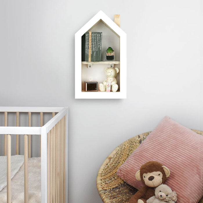 House shaped nursery shelf in white wall mounted in nursery.