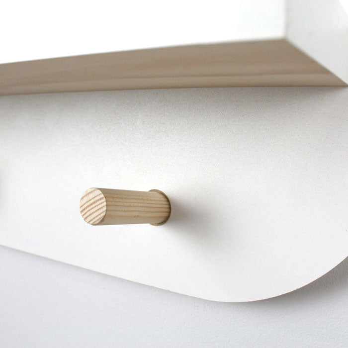 Cloud shaped nursery shelf in white with peg hangers detail.