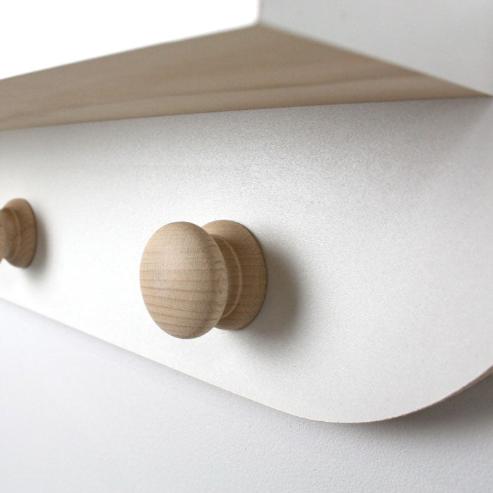Cloud shaped nursery shelf in white with knob hangers detail.