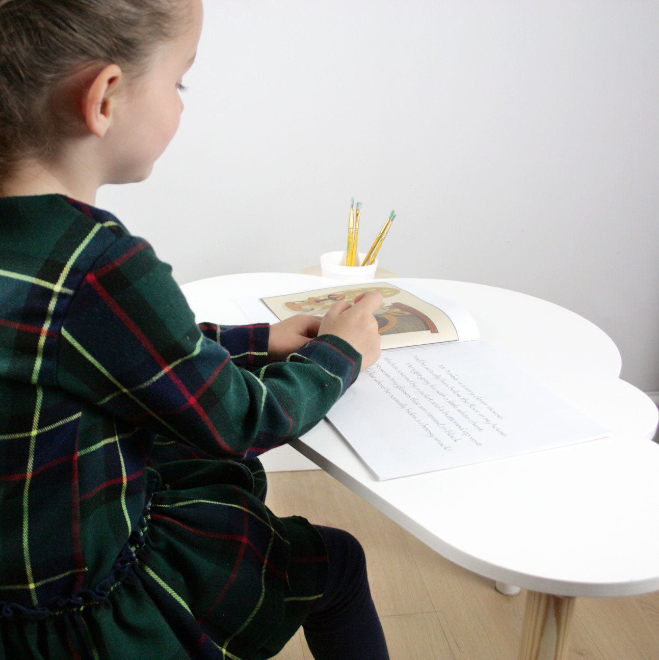 Child reading on cloud shaped desk