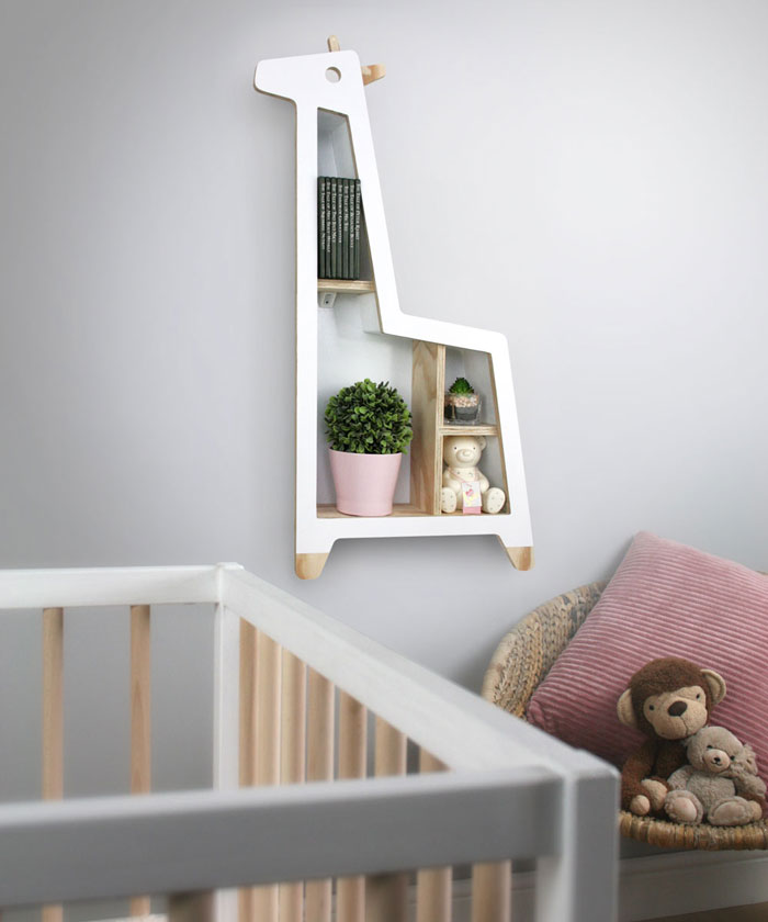 Giraffe shaped nursery shelf in white in nursery room setting.