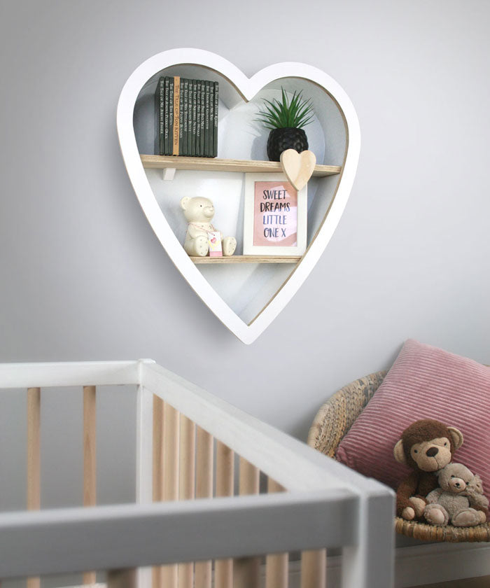 Heart shaped nursery shelf in white wall mounted in babies nursery room deco.