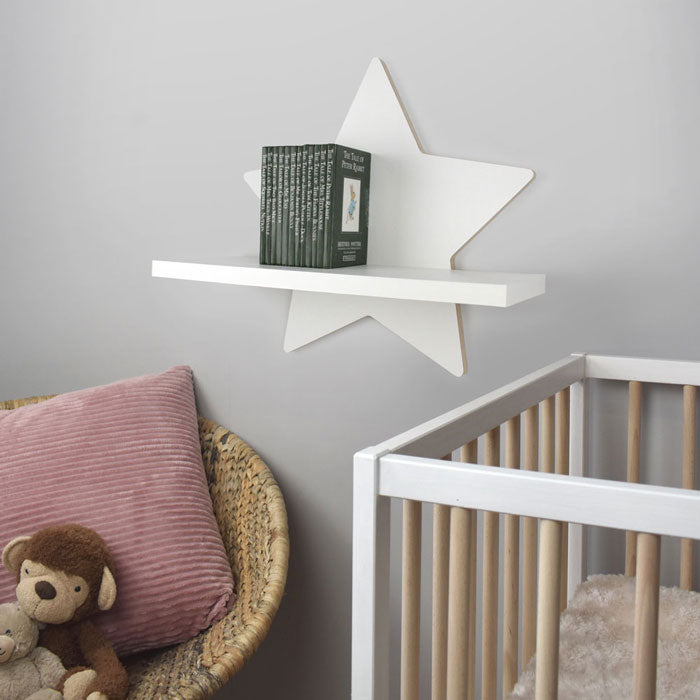 Star shaped nursery shelf in white wall mounted in nursery room.
