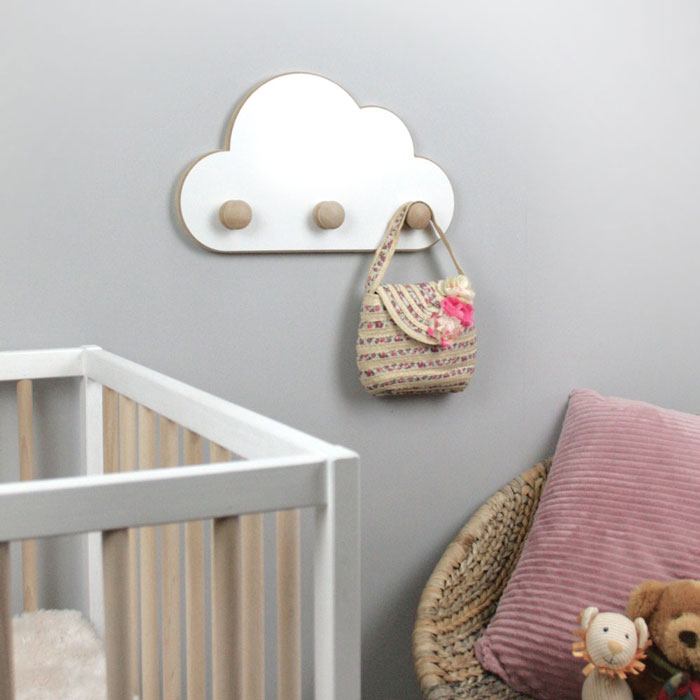 Cloud shaped nursery hangers with knobs wall mounted in nursery.