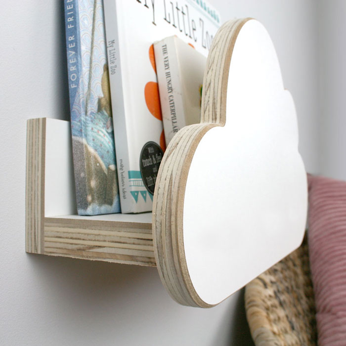 Cloud shaped nursery wall mounted book shelf in white. in white inner detail set in nursery.